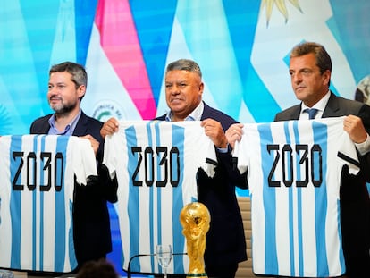 Mattias Lammens (i), ministro de Deportes de Argentina, Claudio Tapa (c), presidente de la Asociación de Fútbol de Argentina (AFA) y Sergio Massa (d), ministro de Economía, muestran camisetas conmemorativas de Mundial 2030.