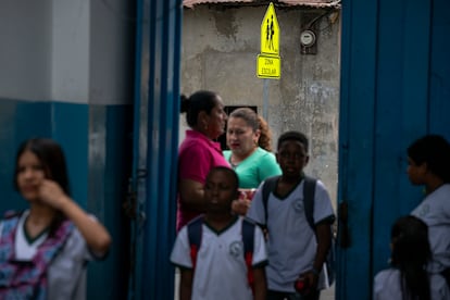 Docentes y madres de familia reciben en la puerta a los alumnos de la jornada vespertina en la escuela, en Guayaquil el 9 de julio, 2025 