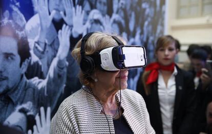 La alcaldesa de Madrid, Manuela Carmena, prueba unas gafas de realidad virtual durante la inauguración de la exposición del 40 aniversario de EL PAÍS.