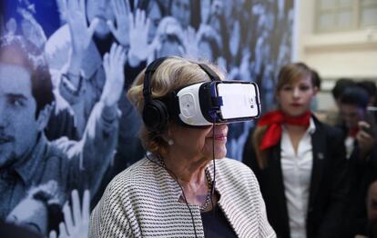 La alcaldesa de Madrid, Manuela Carmena, prueba unas gafas de realidad virtual durante la inauguraci&oacute;n de la exposici&oacute;n del 40 aniversario de EL PA&Iacute;S. 