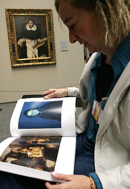 Una periodista consulta el catálogo de la exposición. Al fondo, el cuadro <i> Fray Hortensio Félix Paravicino</i>, pintado por El Greco en 1609.