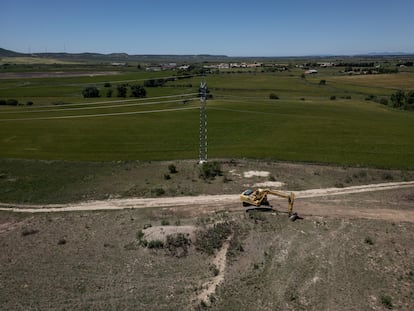 Una excavadora trabaja sobre los terrenos cercanos al polígono de Walqa, en Huesca, donde Amazon Web Services (AWS) está construyendo un nuevo centro de datos como parte de su plan de expansión en Aragón. Al fondo de la imagen, la pedanía de Cuarte.