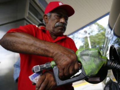 A man fills up his car with gas in Caracas.