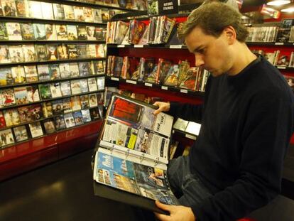 Un hombre revisa el catálogo de películas de Lumière&Lumière. 
 