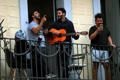 Vecinos de L'Hospitalet cantan en su balcón coincidiendo con la hora del aplauso a los sanitarios.