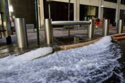 Una bomba de agua vacía un sótano inundado en un edificio en Wall Street durante las labores de limpieza y recuperación de los daños ocasionados por el ciclón "Sandy" en la ciudad de Nueva York, Estados Unidos. EFE/Archivo