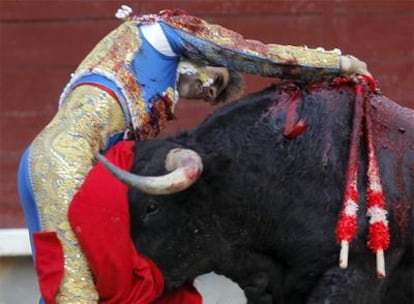 José Tomás entra a matar volcado entre los pitones de su primer toro, en la corrida de ayer en la plaza de Las Ventas.