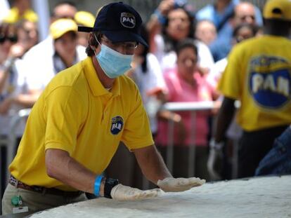 El presidente de Polar, Lorenzo Mendoza, ayuda a preparar una arepa gigante en un acto celebrado en Caracas en 2011. 