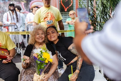 Un miembro de la comunidad se toma una foto con María Antonia Cay.