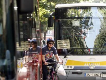 Un ciclista se abre paso entre dos autobuses.