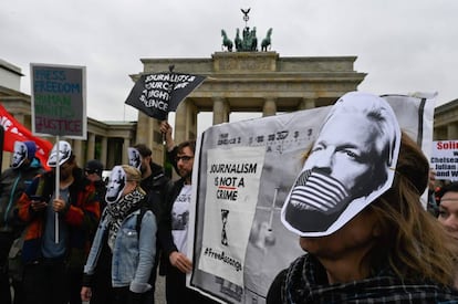 Manifestantes protestan por el arresto de Assange con máscaras con su cara, este jueves en Berlín.