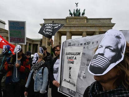 Manifestantes protestan por el arresto de Assange con máscaras con su cara, este jueves en Berlín.