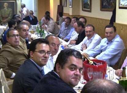 Imagen de la cena en la que cargos de instituciones de Castellón aparecen sentados a una mesa presidida por el retrato de Franco.