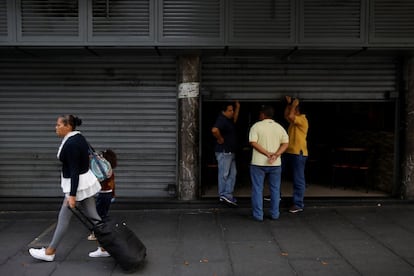 Comerciantes conversam na entrada de um restaurante que fechou suas portas após o blecaute nacional.