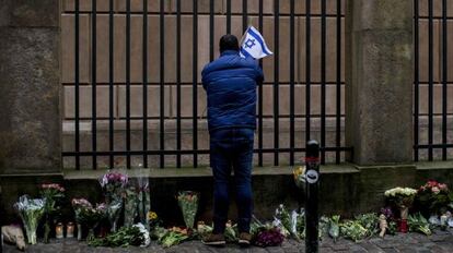 Un hombre pone una bandera israelí en la sinagoga de Copenhague.