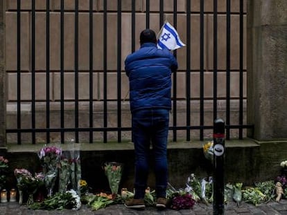 Un hombre pone una bandera israel&iacute; en la sinagoga de Copenhague.