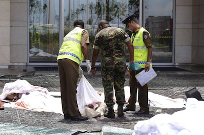 Agentes de segurança inspecionam os restos mortais de várias pessoas vítimas no atentado do Hotel Shangri-A, em Colombo.