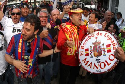 Manolo el del Bombo comparte el ambiente festivo, a las puertas de Mestalla, con aficionados del Barça y del Madrid.