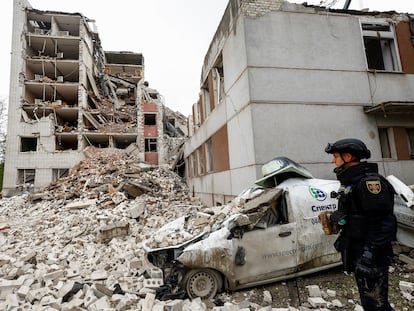 Un oficial del Servicio Estatal de Emergencia de Ucrania observa mientras los rescatistas trabajan junto a un edificio destruido durante un ataque con misiles rusos, en Chernihiv, este miércoles.