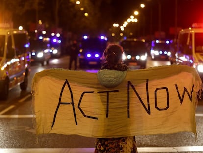 Una mujer sostiene una manta con la frase "Actúen ahora", durante una cumbre climática de Naciones Unidas.
