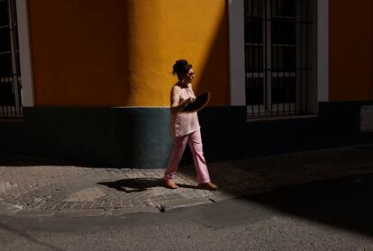 Una mujer se abanica, este lunes 21 de agosto, mientras pasea por Sevilla. 