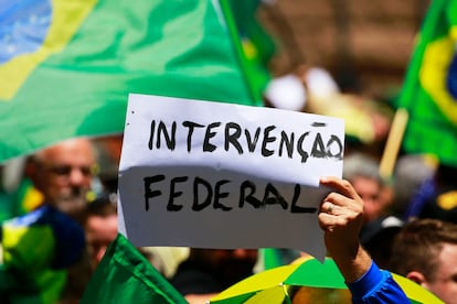 Un manifestante levante un cartel con la frase "Intervención federal", a las afueras de un cuartel militar en Porto Alegre.