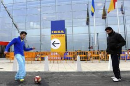 Dos chicos juegan al fútbol a las puertas del nuevo establecimento de IKEA en Valladolid. EFE/Archivo