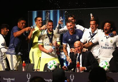 Los juagadores del Madrid roc&iacute;an a Zidane con champ&aacute;n tras ganar la Superocopa de Europa al Sevilla. 