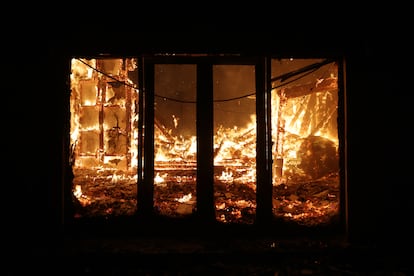 Una casa arde durante el incendio forestal en el pueblo de Varnava, al norte de Atenas, el domingo.