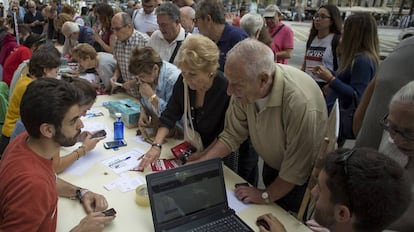 Varios jóvenes universitarios informan del lugar donde votar el próximo domingo, en el referéndum ilegal del 1-O, en Barcelona.