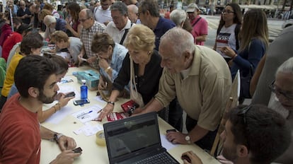 Varios j&oacute;venes universitarios informan del lugar donde votar el pr&oacute;ximo domingo, en el refer&eacute;ndum ilegal del 1-O, en Barcelona.