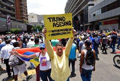 Un manifestante contrario al presidente Nicolás Maduro sostiene una pancarta en la que se puede leer 'Tirano, asesino' en referencia al sucesor de Chávez durante la manifestación contra del gobierno venezolano.