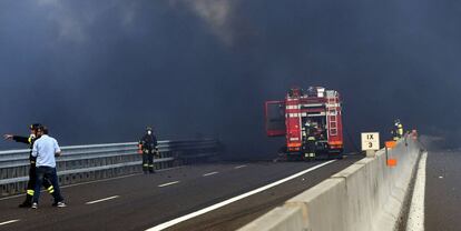 Firefighters work at the scene where a tanker truck exploded on a motorway just outside Bologna, northern Italy, on August 6, 2018.  A tanker truck exploded on a motorway just outside the northern Italian city of Bologna on August 6, engulfing the area with flames and black smoke, the fire service said, with local media reporting one person killed. The explosion occurred near Borgo Paginale to west of the city, very close to Bologna airport, at around 2:00 pm (1200 GMT), the Italian fire service said on Twitter.   / AFP PHOTO / -