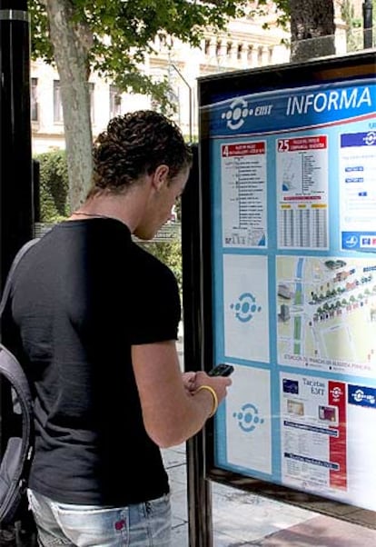Un joven compra un billete de autobús por Mobipay, en Málaga.