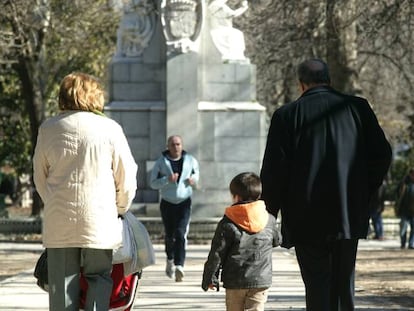 Unos abuelos pasean con sus nietos en el Parque del Retiro en Madrid.