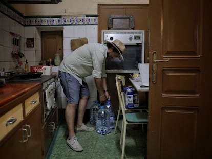 El hijo de un vecino de L'Albi (Lleida) sube garrafas de agua a su casa, en junio pasado, durante un episodio de contaminación del agua potable.