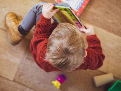 Un niño lee en su casa.