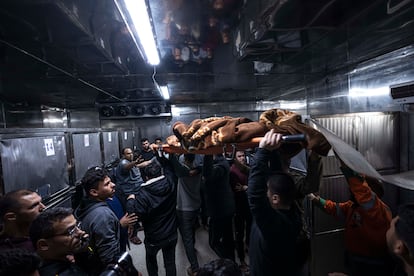 The body of a Palestinian killed in an Israeli airstrike, is carried into the morgue of Al-Shifa Hospital in Gaza City, on May 9, 2023.