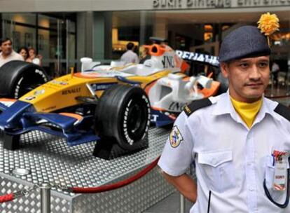 Un agente de seguridad vigila un monoplaza de Renault en Sepang.