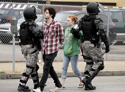 Dos agentes policiales detienen a dos manifestantes en Pittsburgh.