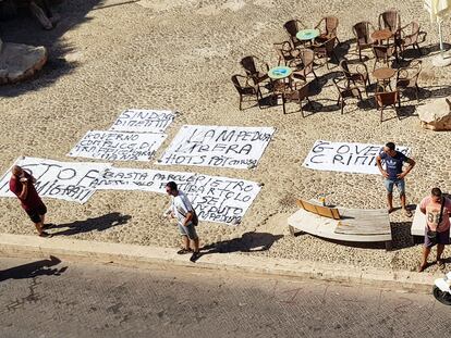 Residentes de Lampedusa ponen pancartas en señal de protesta contra el Gobierno central ante la falta de gestión de la inmigración en la isla, este lunes.