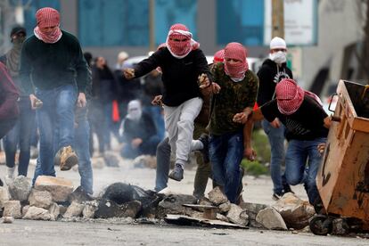 Un grupo de manifestantes palestinos corren durante los enfrentamientos con las fuerzas israelíes cerca del asentamiento judío de Beit El, en Ramala.