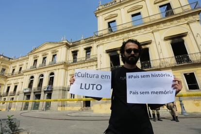 Un hombre muestra un cartel en el que se lee "Cultura en luto" frente al Museo Nacional de Río de Janeiro.