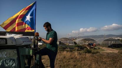 Un hombre cuelga una estelada a su tractor antes de ir a manifestarse a Barcelona.