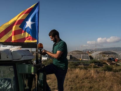 Un hombre cuelga una estelada a su tractor antes de ir a manifestarse a Barcelona.