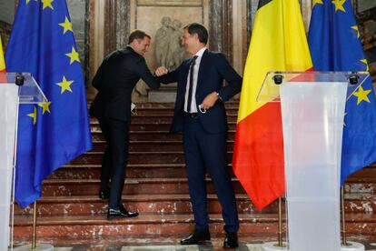 El futuro primer ministro belga, el liberal flamenco Alexander De Croo (a la derecha) saluda al socialista valón Paul Magnette, con quien ha liderado las negociaciones, durante la rueda de prensa en la que se ha anunciado la formación del gobierno belga esta mañana.