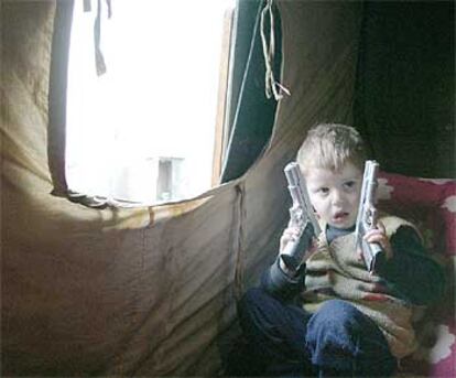 Un niño juega en el interior de una tienda de campaña en el campo de refugiados chechenos de Karabulak, en Rusia.