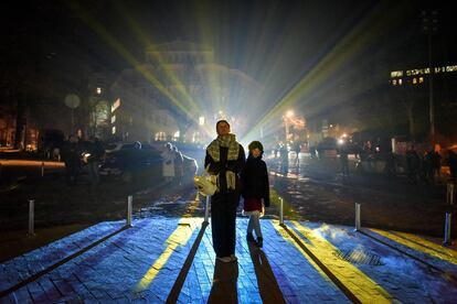 Varios ciudadanos ucranios contemplan la iglesia de Andriivska iluminada por el artista suizo Gerry Hofstetter, en Kiev, el pasado 23 de diciembre.