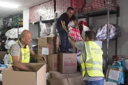 Varios agentes de la Guardia Civil empaquetan los cientos de paquetes de tabaco que se han incautado en el puerto de Algeciras, junto a la barrera de entrada que hay cerca de cabotaje.