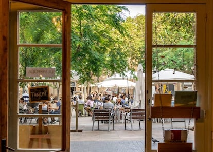 La Plaça d’Osca, en el barrio barcelonés de Sants, vista desde el interior de la librería Barra/Llibre.